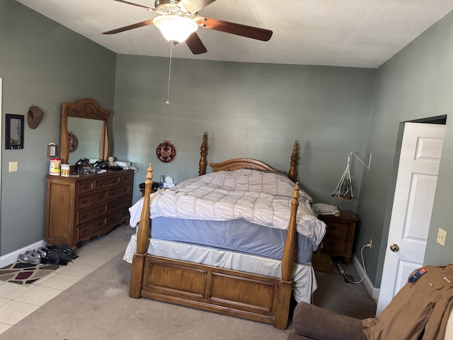 bedroom with a textured ceiling, ceiling fan, baseboards, and tile patterned floors