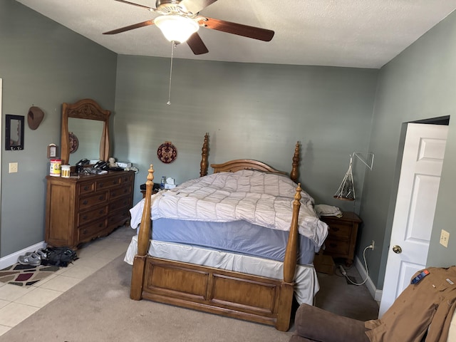 bedroom with light tile patterned floors, ceiling fan, a textured ceiling, and baseboards