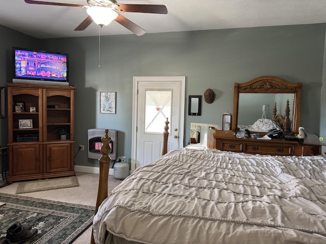 bedroom featuring light colored carpet, baseboards, heating unit, and ceiling fan