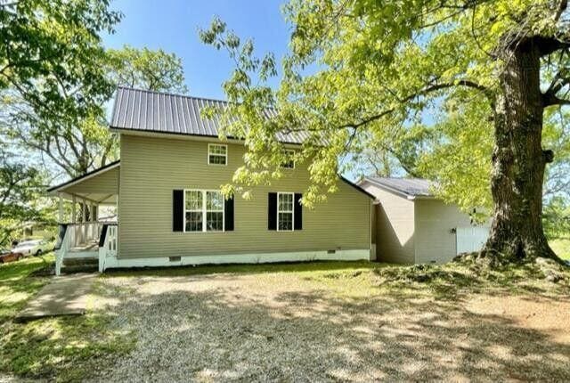 rear view of house with crawl space and metal roof