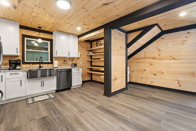 kitchen featuring light stone counters, hanging light fixtures, stainless steel dishwasher, white cabinetry, and a sink