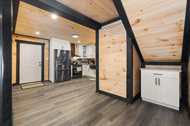 kitchen with stainless steel appliances, wood ceiling, white cabinets, wall chimney range hood, and glass insert cabinets