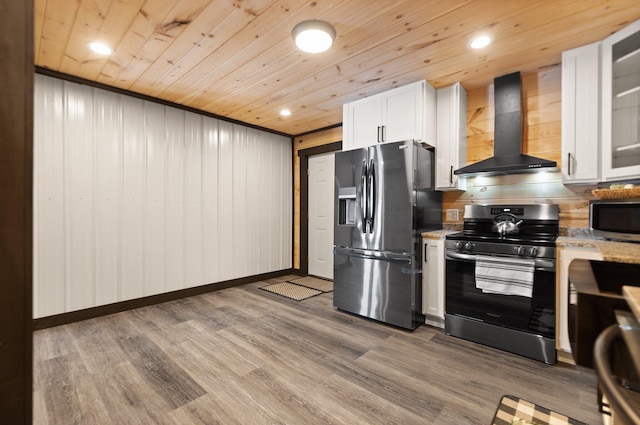 kitchen featuring stainless steel appliances, white cabinets, wall chimney range hood, light stone countertops, and glass insert cabinets