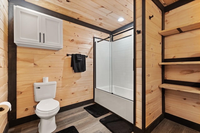 full bath with combined bath / shower with glass door, wood walls, and wood finished floors