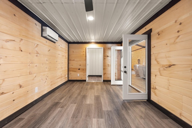 empty room with dark wood finished floors, wood ceiling, french doors, wood walls, and a wall mounted AC