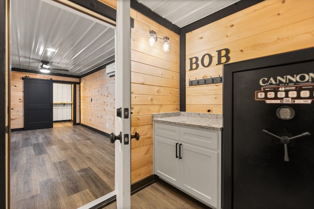 interior space featuring wooden walls, an AC wall unit, and wood finished floors