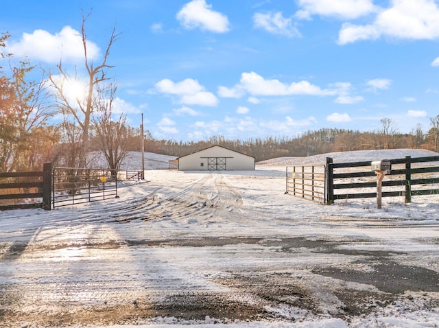 view of road featuring driveway, a pole building, and a rural view