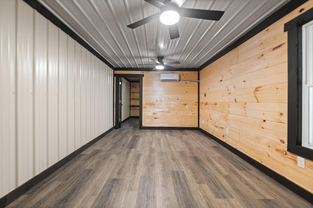 empty room with a ceiling fan, a wall mounted air conditioner, and wood finished floors