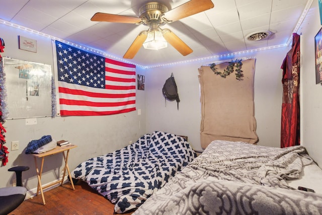 bedroom with dark wood-style flooring, visible vents, and a ceiling fan