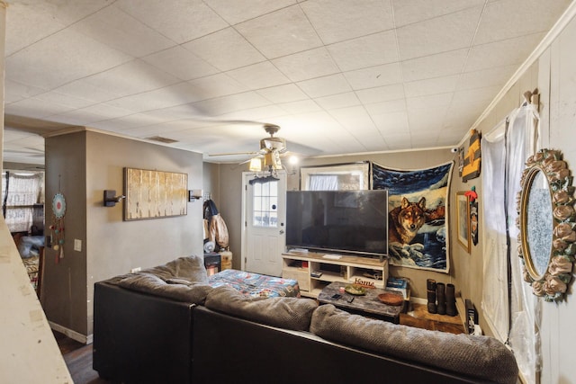 living room with visible vents, ornamental molding, ceiling fan, wood finished floors, and baseboards