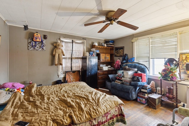 bedroom featuring ornamental molding, light wood-style flooring, and a ceiling fan