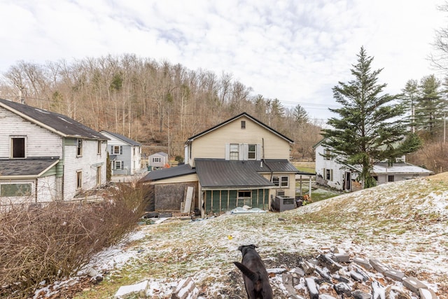 back of property featuring metal roof and central AC