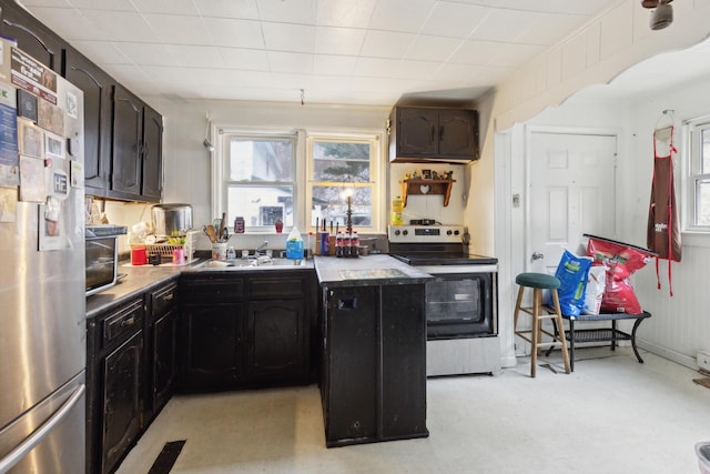 kitchen featuring stainless steel appliances, a sink, and light countertops