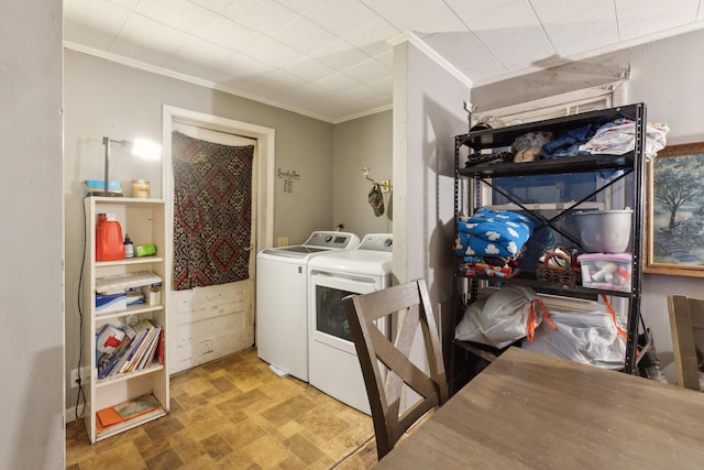 laundry area with crown molding, laundry area, stone finish flooring, and washer and dryer