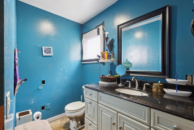 half bath featuring toilet, wood finished floors, vanity, and baseboards