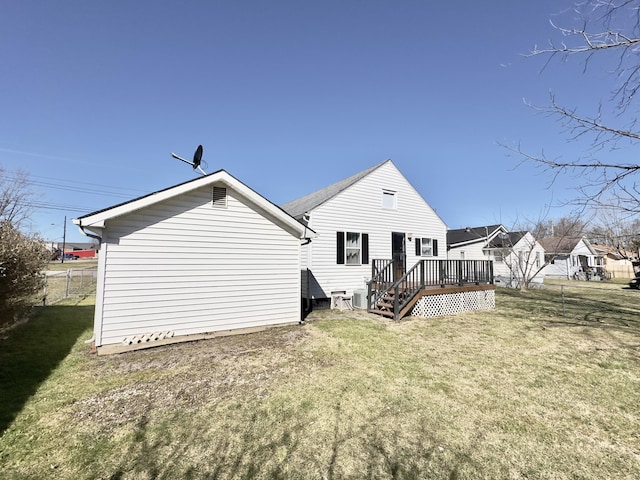 back of house with a lawn, a wooden deck, and fence