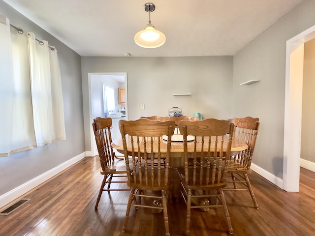 dining space with visible vents, baseboards, and wood finished floors