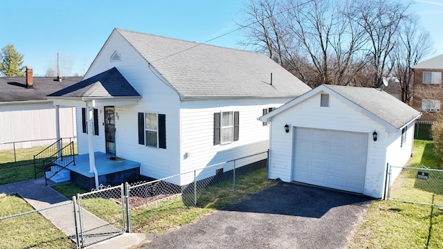 view of front of property with driveway, fence private yard, a gate, and an outbuilding