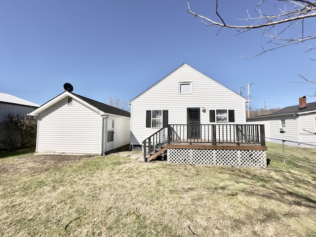 rear view of property with an outbuilding, a yard, a deck, and fence