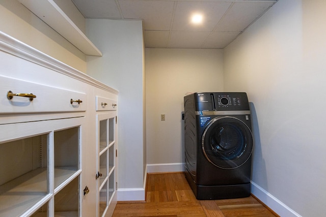 laundry room featuring wood finished floors, washer / clothes dryer, baseboards, and laundry area