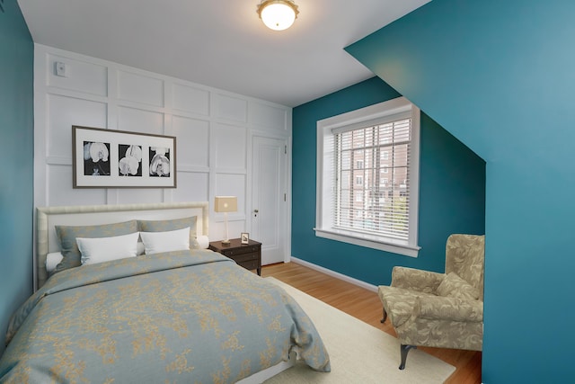 bedroom with light wood finished floors and baseboards