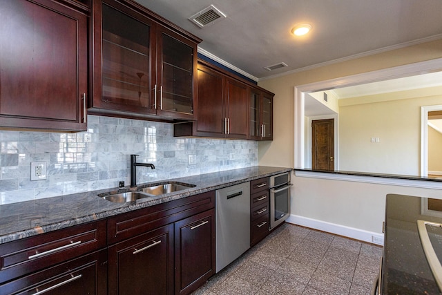 kitchen featuring granite finish floor, a sink, baseboards, appliances with stainless steel finishes, and glass insert cabinets