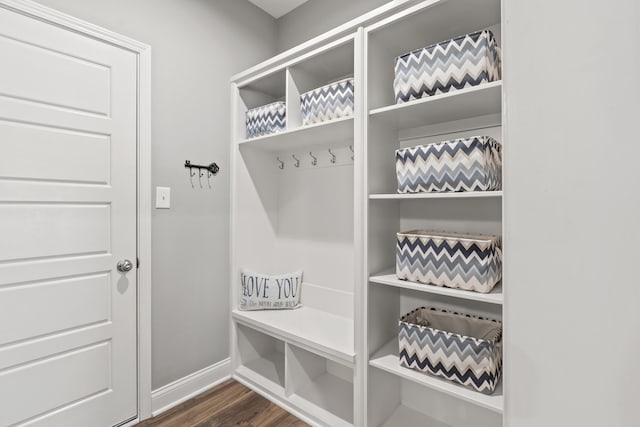 mudroom with dark wood-style floors and baseboards