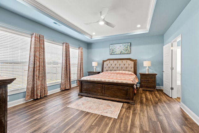 bedroom featuring dark wood-style floors, a tray ceiling, and baseboards