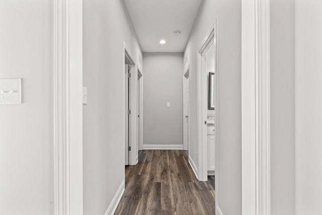 hallway featuring dark wood-style floors and baseboards