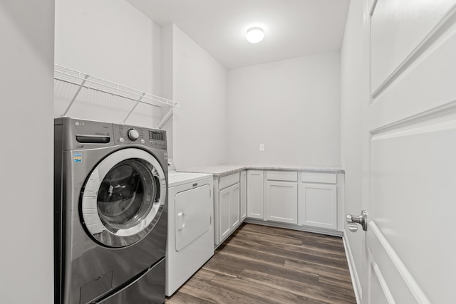 laundry room featuring dark wood-style floors, washing machine and dryer, and cabinet space