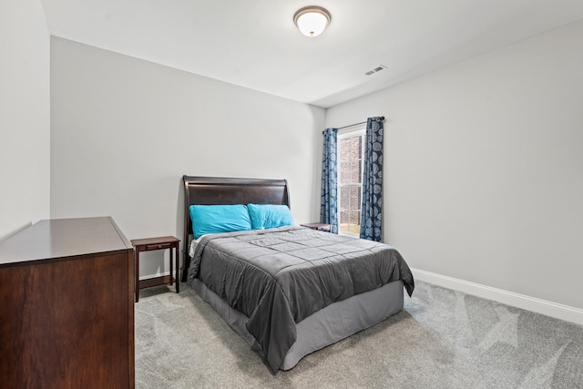 bedroom featuring baseboards, visible vents, and light colored carpet