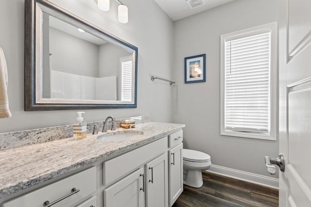 full bathroom with visible vents, baseboards, toilet, wood finished floors, and vanity