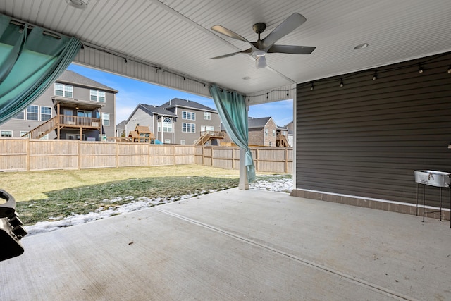 view of patio featuring a ceiling fan, a residential view, and fence