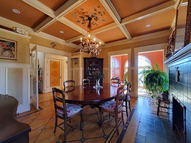 dining area with beamed ceiling, a premium fireplace, coffered ceiling, and a notable chandelier