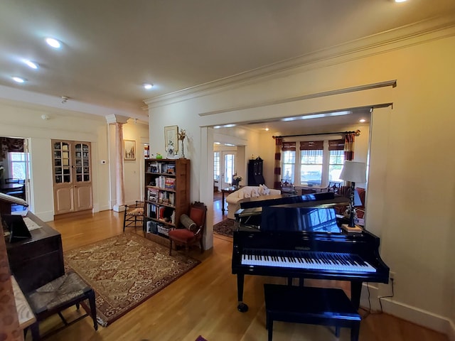 interior space featuring crown molding, recessed lighting, ornate columns, wood finished floors, and baseboards