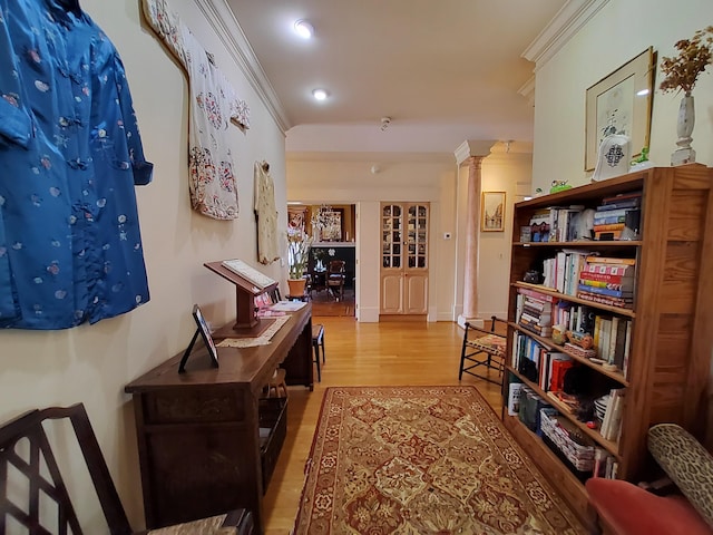 hall with ornamental molding, recessed lighting, decorative columns, and light wood-style floors