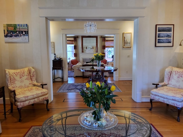 living room with a chandelier, baseboards, and wood finished floors