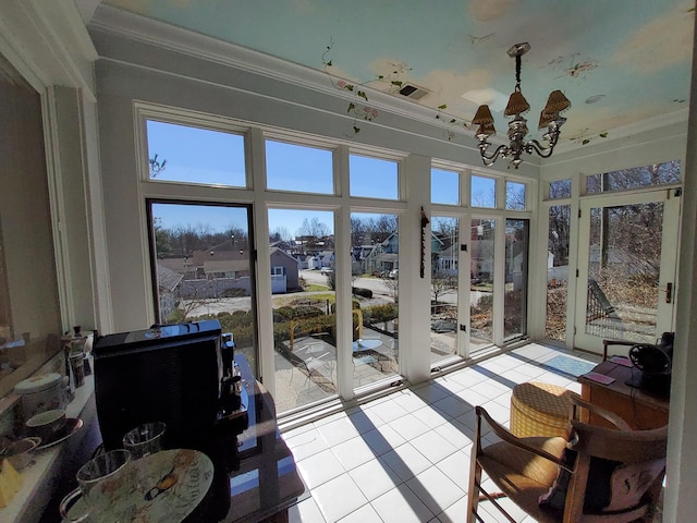 sunroom with a chandelier and a residential view