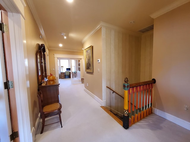 corridor with visible vents, an upstairs landing, baseboards, ornamental molding, and carpet