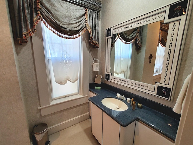 bathroom with a wealth of natural light, vanity, and baseboards