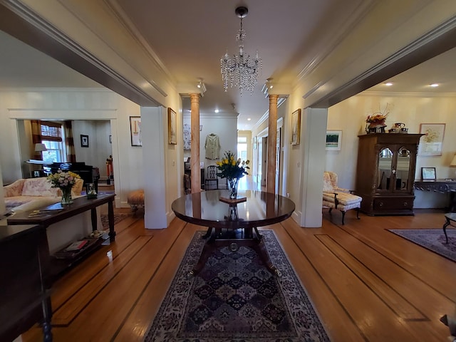 hallway featuring ornamental molding, ornate columns, and wood finished floors