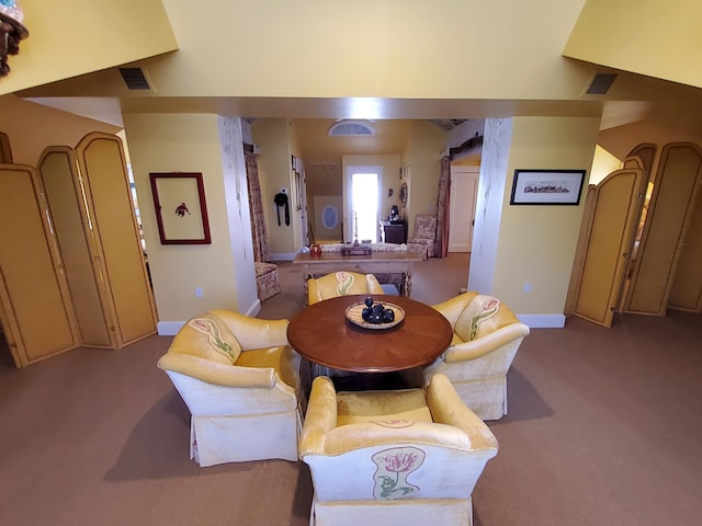 dining room with baseboards, visible vents, and light colored carpet