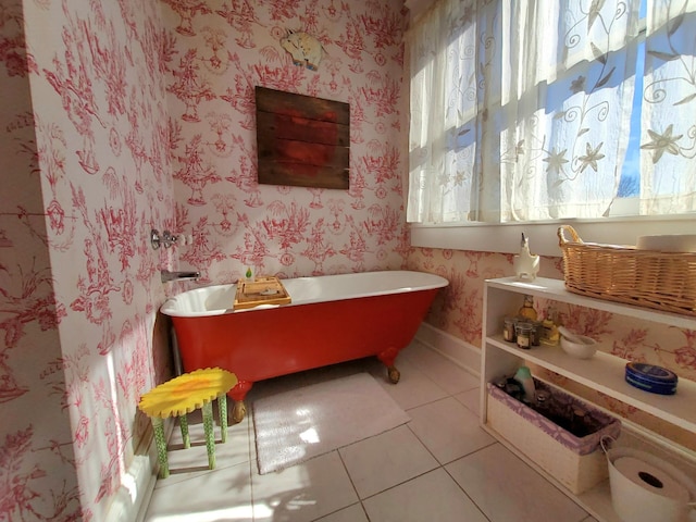 bathroom featuring tile patterned flooring, a soaking tub, baseboards, and wallpapered walls