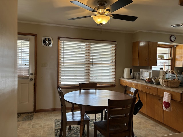 dining space featuring baseboards, visible vents, and crown molding