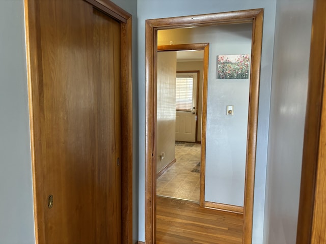 hall with light wood-type flooring and baseboards