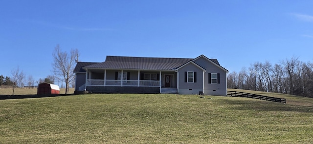 view of front of house featuring a porch, a front yard, metal roof, an outdoor structure, and crawl space