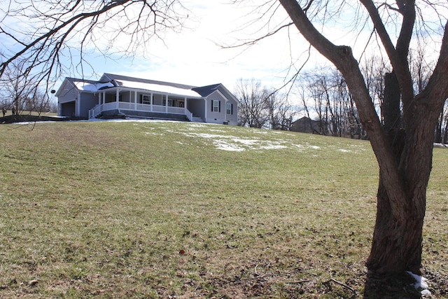 view of front of property featuring a garage, covered porch, and a front yard