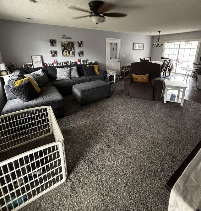 living room featuring carpet flooring, a textured ceiling, and ceiling fan with notable chandelier