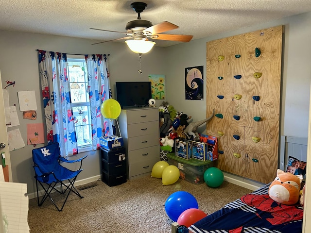 game room with a textured ceiling, ceiling fan, carpet floors, and baseboards