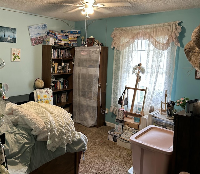 carpeted bedroom featuring a ceiling fan and a textured ceiling